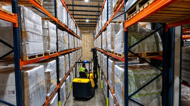 Articulated forklift working in a very narrow warehouse aisle