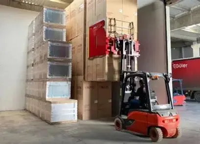 Forklift with a carton clamp handling boxed appliances