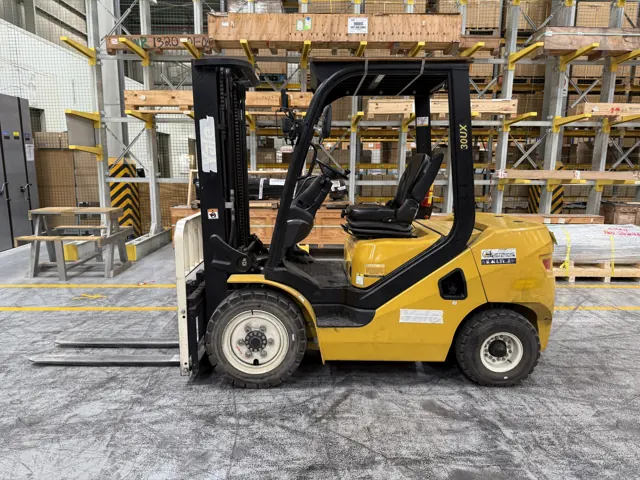 Yellow diesel counterbalance forklift in front of pallet racking