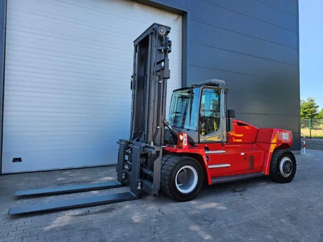 Red diesel forklift with a high mast outside a warehouse