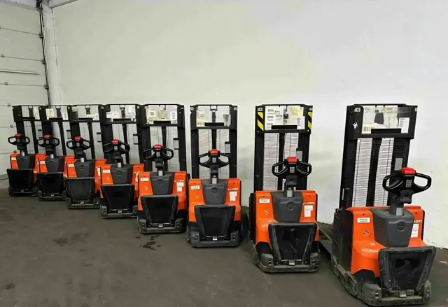 Row of orange electric pallet stackers