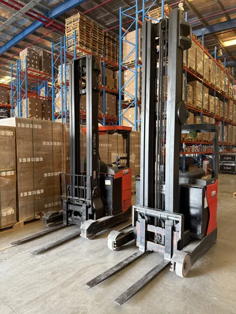 Two reach trucks with forks lowered, front view in a warehouse