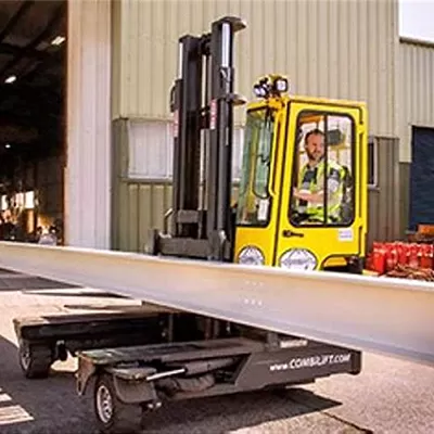 Yellow forklift loading materials onto trailer