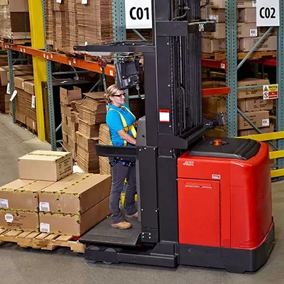 Electric reach truck operating in warehouse racks