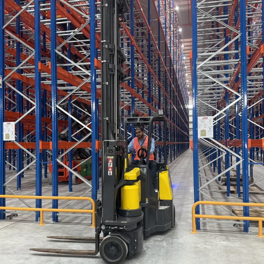 Aisle-Master articulated forklift with an operator inside a narrow racking aisle