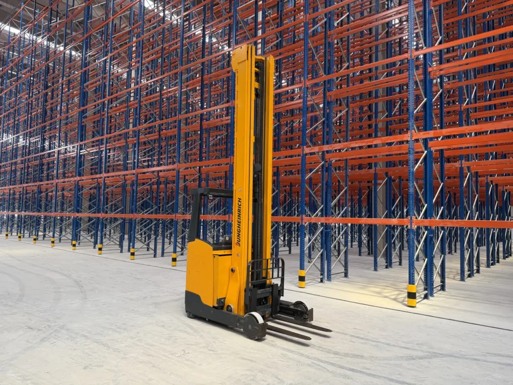 Electric reach truck in a high-bay pallet racking warehouse